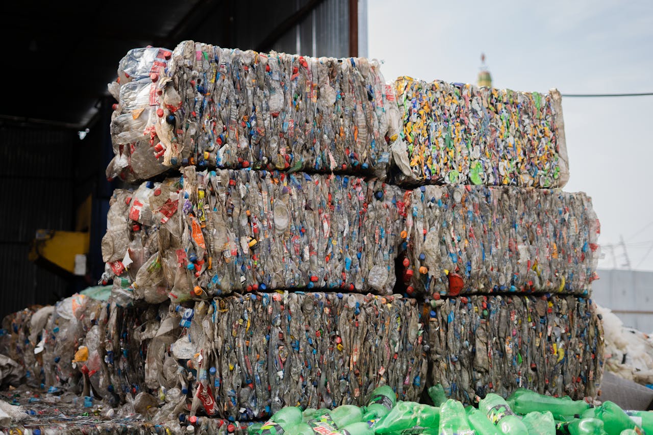 Stacked compressed plastic bottles at a recycling facility, ready for processing.